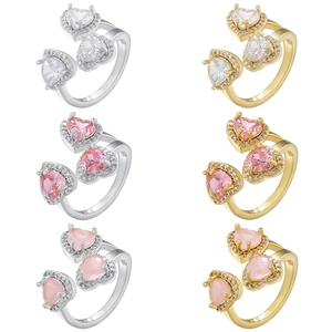 Dettaglio degli anelli con cristalli rosa a cuore in finiture oro e argento lucido