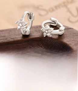 Detail view of silver flower earrings with zircons and an 8mm inner diameter measurement