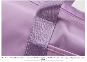 Close-up of reinforced X-shaped stitching on the handle of this purple travel bag