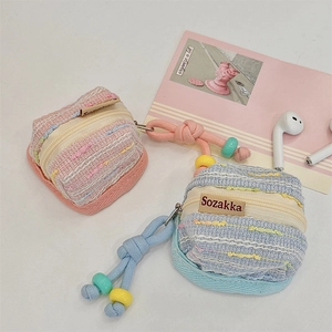 Detailed texture of tweed storage pouch for wireless earbuds with beaded lanyard