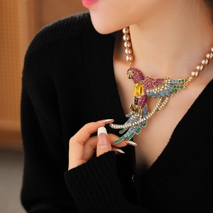 Detail of parrot pendant with colorful rhinestones and champagne pearl necklace on model