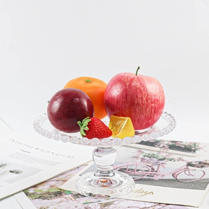Clear silicone tray mold with bead rim and assorted realistic fruit models on a table