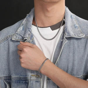 Silver stainless steel Cuban link necklace and bracelet set worn by a male model