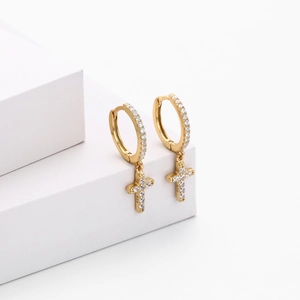 Close-up of gold S925 sterling silver hoop earrings with zircon cross charms on white stone