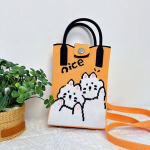 Detail of orange knitted handbag with pixel cat pattern and metal snap closure