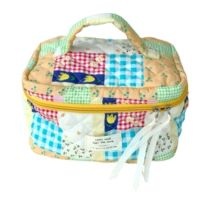 Quilted cotton handheld cosmetic bag with colorful patchwork floral and plaid patterns