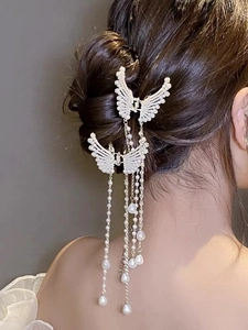 Detailed view of elegant butterfly hair claw with long hanging pearl tassels on hair