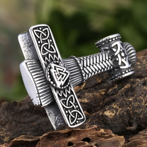 Macro shot of silver Viking Mjolnir pendant with Celtic knot on rustic wood background