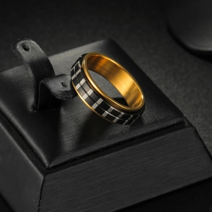 Macro view of black rotatable ring with silver checkered pattern and gold interior