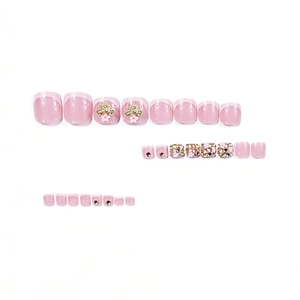 Short square pink French press-on toenails with gold bows and sparkling diamond accents