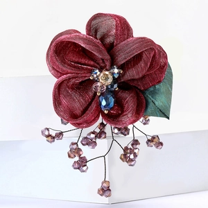 Detailed close-up of wine red lace flower brooch with crystal beads and tassels