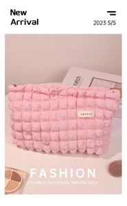 Detalle del neceser rosa con textura de burbujas, logo H&R BAG y cremallera