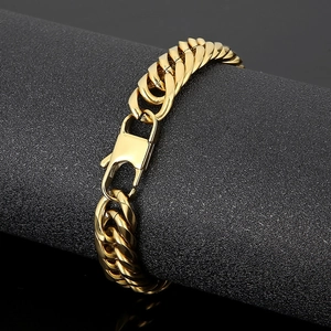 Macro shot of gold-plated Cuban chain link bracelet with lobster clasp on black stand
