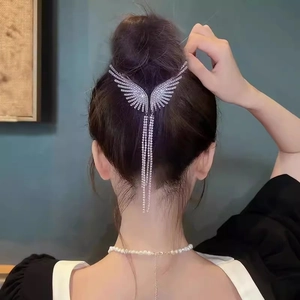 Close-up of elegant silver wing hair claw with sparkling rhinestones and long tassels