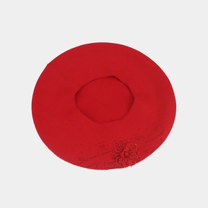 Dettaglio del basco in maglia rossa con ricamo floreale vintage e perline delicate
