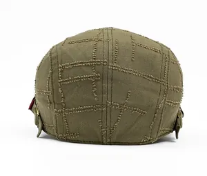 Detail of vintage army green beret with distressed mesh stitching and adjustable metal buckle