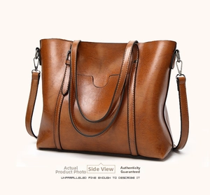 Detailed side view of the brown soft leather bucket bag with silver metal buckles