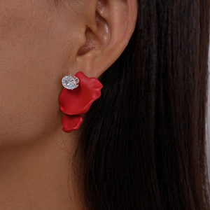 Detail of red petal earring with zircon stone worn by a model in a close-up shot