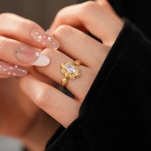 Nahaufnahme von Vintage-Goldring mit ovalem lila Edelstein und floralen Diamant-Akzenten
