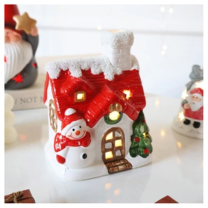 Glow-in-the-dark ceramic Christmas snow house with festive tree and snowman detail