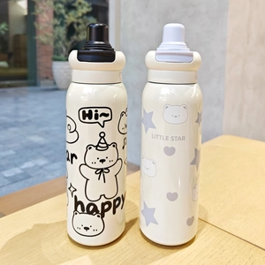 Detail of cartoon stainless steel thermal bottles with bear prints on a wooden table