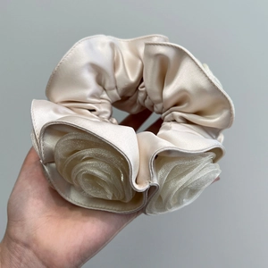 Detailed view of handmade cream satin scrunchie with layered 3D tulle rose flowers
