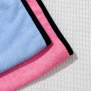 Close-up of thick light blue and pink coral fleece pet towels with soft microfiber texture