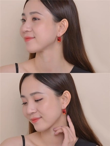 Detailed view of model wearing elegant oval ruby red zircon earrings with gold hooks