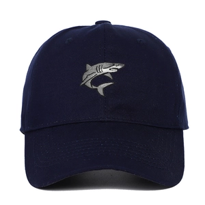 Detailed close-up of realistic shark embroidery on a navy blue cotton baseball cap