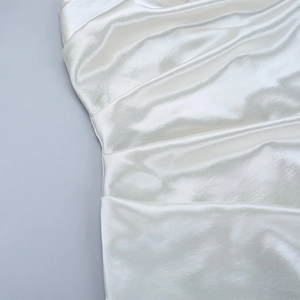 Detailaufnahme von weißem Satinstoff mit glatter Textur und elegantem Faltenwurf