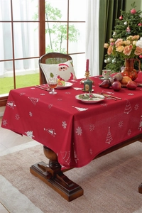 Detail of red Christmas tablecloth featuring white reindeer and snowflake prints