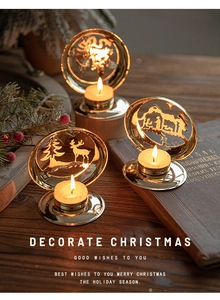 Golden Christmas metal candle holder with hollow deer silhouettes on a wooden table