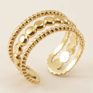 Detailed close-up of a three-layer gold stainless steel ring with beaded and disc textures