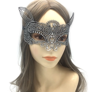 Macro detail of silver lace masquerade mask showing intricate hollow patterns