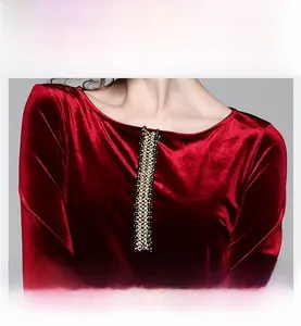 Dettaglio dell'abito in velluto rosso con scollo rotondo e decorazione verticale di paillettes