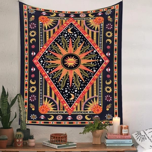 Detail of bohemian sun and moon tapestry on a white wall with potted plants below
