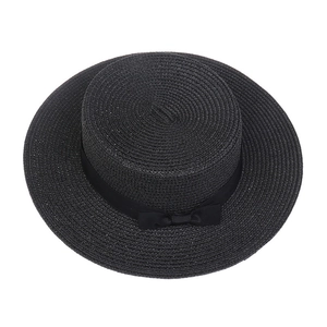 Close-up of black straw boater hat featuring a flat brim and elegant ribbon bow detail