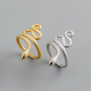 Exaggerated gold and silver snake rings with detailed scale texture and open design