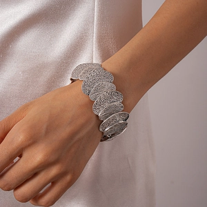 Macro detail of silver hammered texture cuff bracelet showing irregular geometric metal patterns