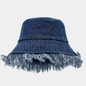 Detail of frayed edges and distressed fringe on a heavy denim bucket hat in dark blue