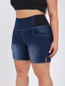 Detail of high-waist denim shorts with black elastic side panels and side slits