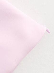 Detail of high-quality hidden zipper on light pink halter top with smooth texture