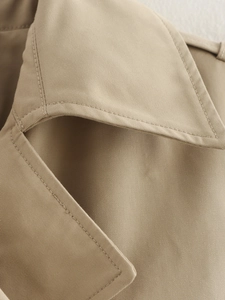 Detailed close-up of khaki cotton twill fabric and premium double stitching on the trench coat