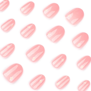 Short round peach pink press-on nails with white floral patterns and silver glitter accents