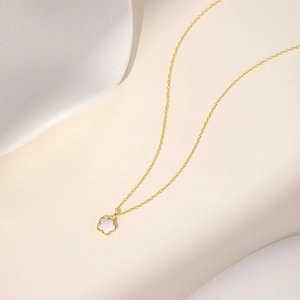 Détail d'un collier doré en argent s925 avec pendentif fleur à cinq pétales en nacre