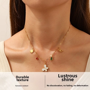 Macro detail of gold-plated necklace featuring diverse star, butterfly and gem pendants