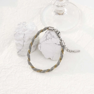 Detail of twisted mesh steel bracelet in gold and silver finish with lobster clasp