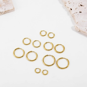 Multiple sizes of classic 18K gold plated stainless steel hoop earrings on stone display