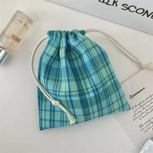 Detailed view of blue and green plaid drawstring bag with cotton cord and soft texture