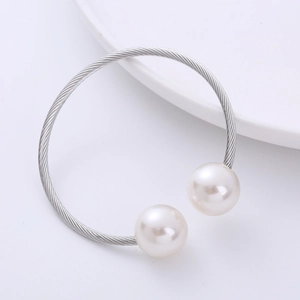 Macro shot of silver-tone wire-wrapped bangle with two large round white pearls